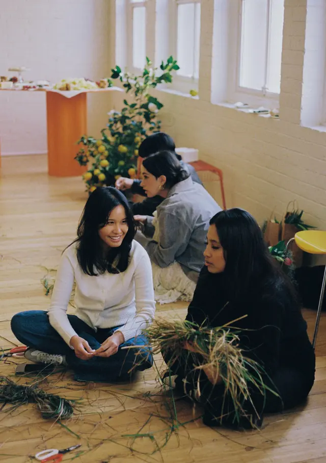 A Flowerclub workshop: guests sitting on the studio floor making bouquets