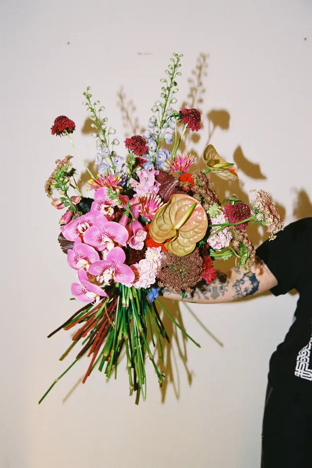 A bouquet of pink anthurium, orchids and garden flowers